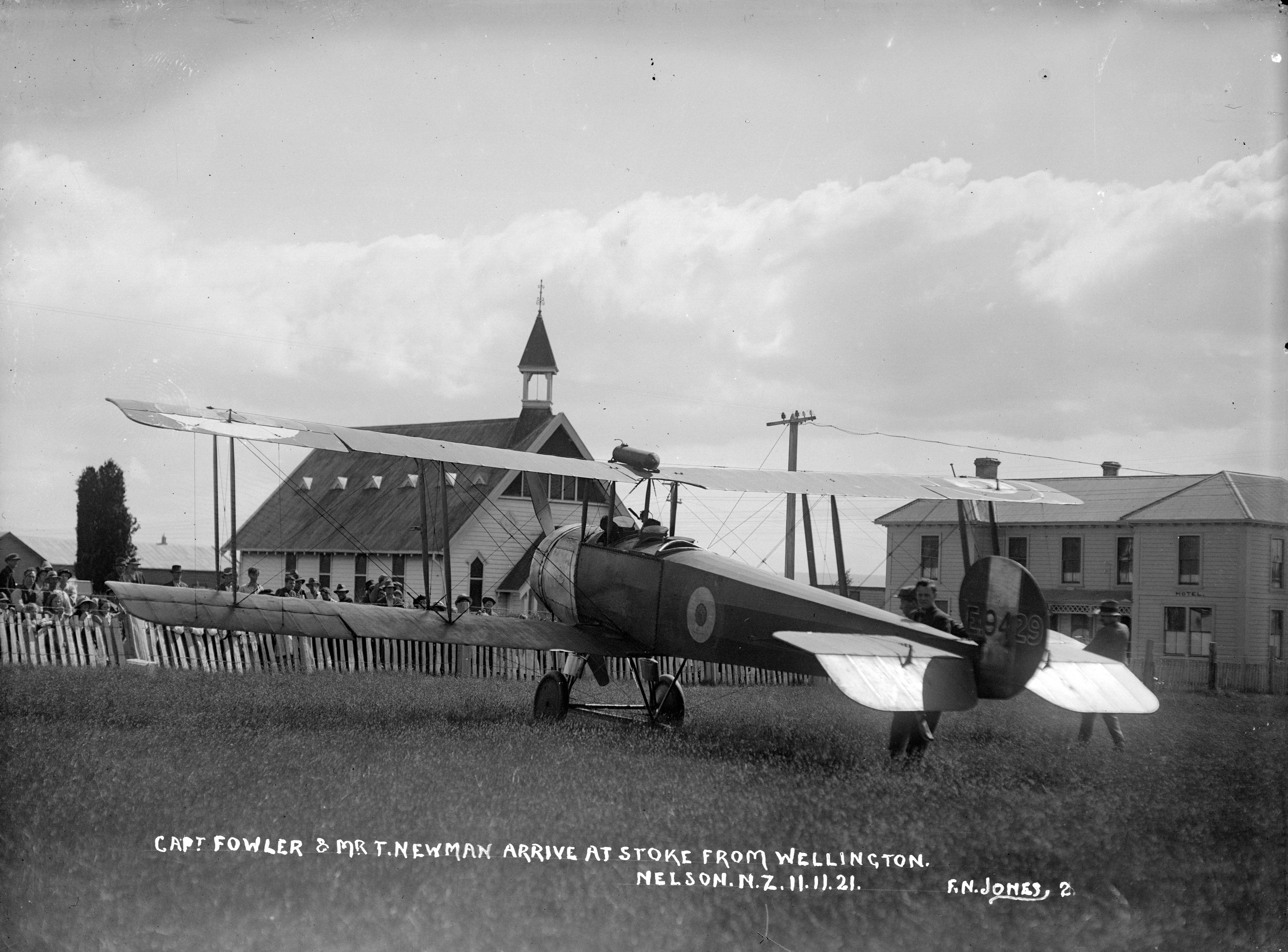 Black and white photo a biplane parked in a field.